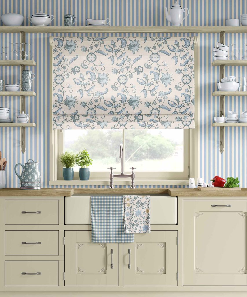 A country style kitchen with blue striped wallpaper, open shelfs and floral window blind